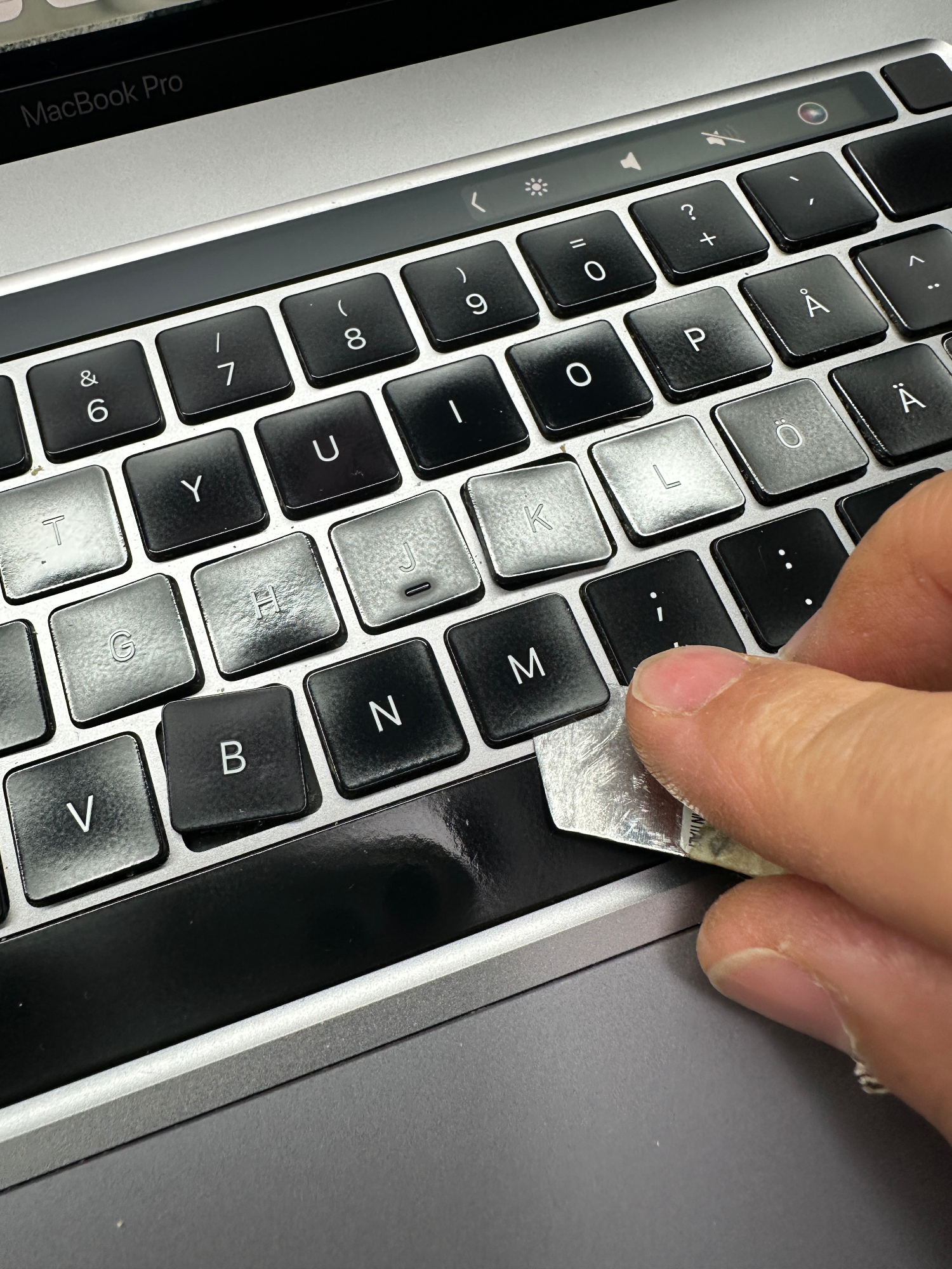 MacBook Pro toets wordt voorzichtig verwijderd voor vervanging van het toetsenbord